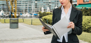 close-up-young-businesswoman-reading-folder-outdoors